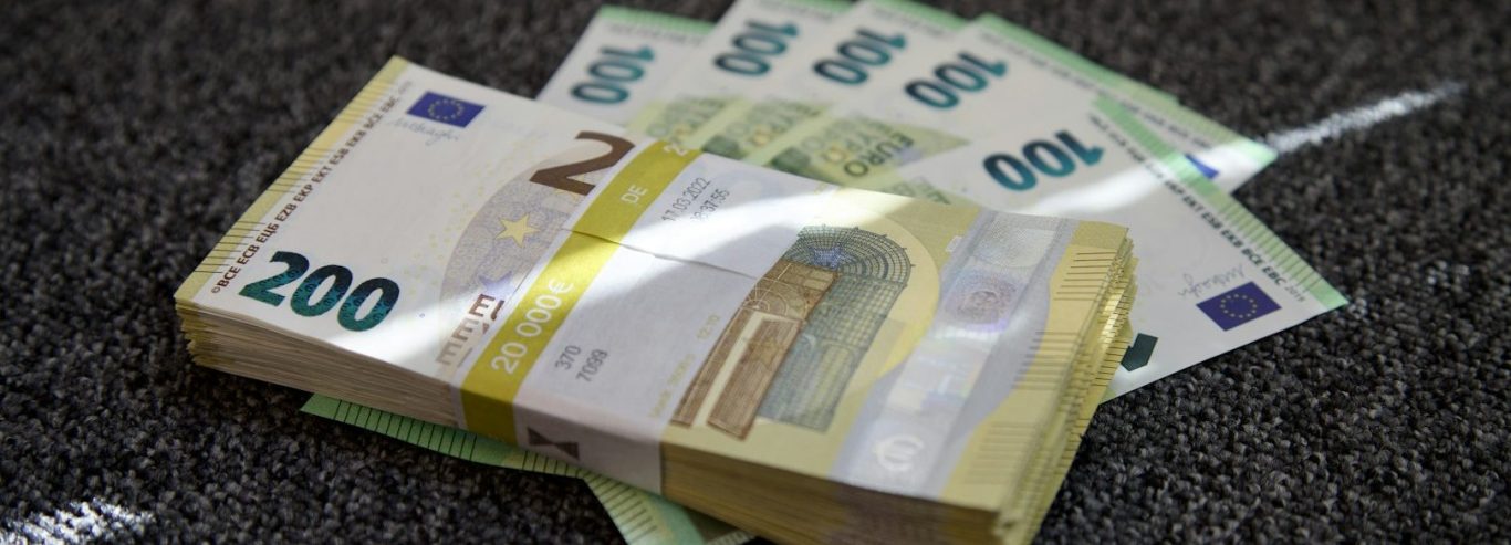 Ein Bündel 200-Euro-Scheine und mehrere 100-, 50- und 20-Euro-Scheine auf einem Tisch.