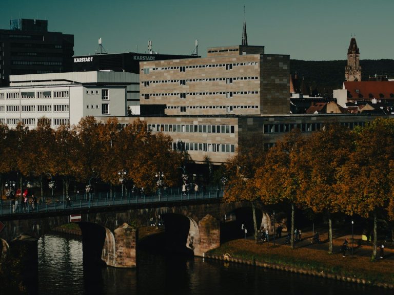 Städtische Landschaft mit einem Fluss, Brücke und modernen Gebäuden im Hintergrund.