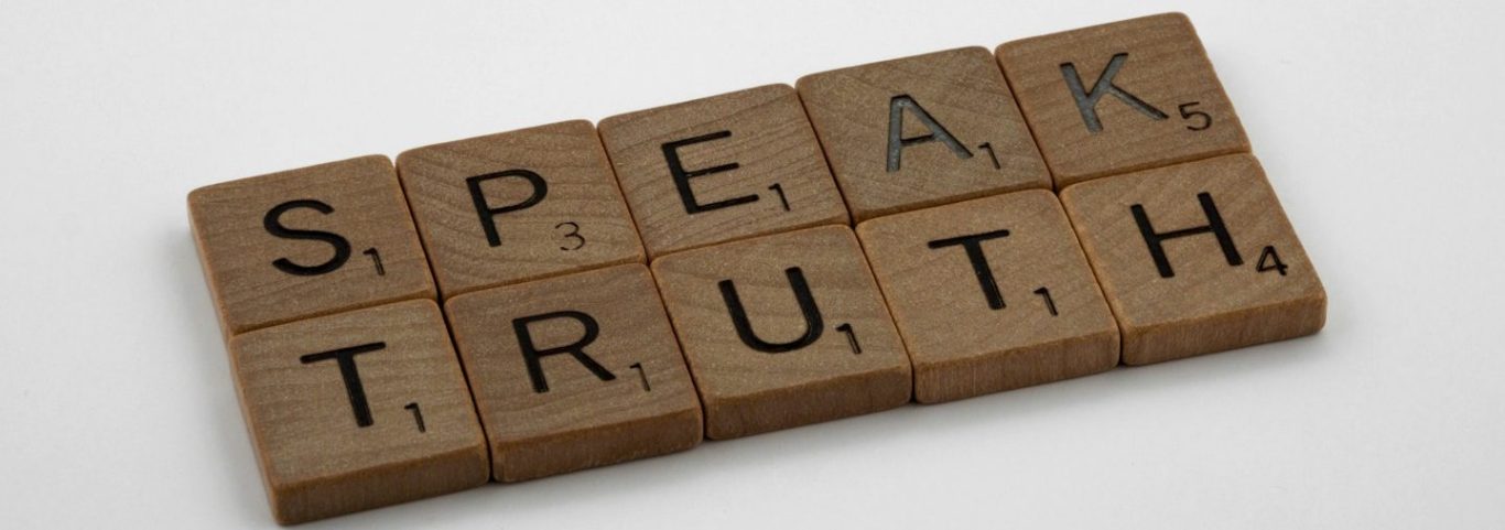 Buchstabensteine mit den Worten "SPEAK TRUTH".