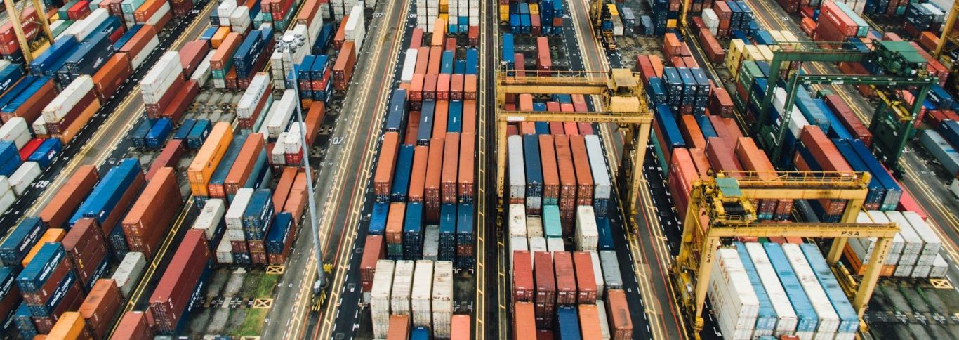 Containerterminal mit vielen bunten Containern und Kranen zur Umschlagtechnik.