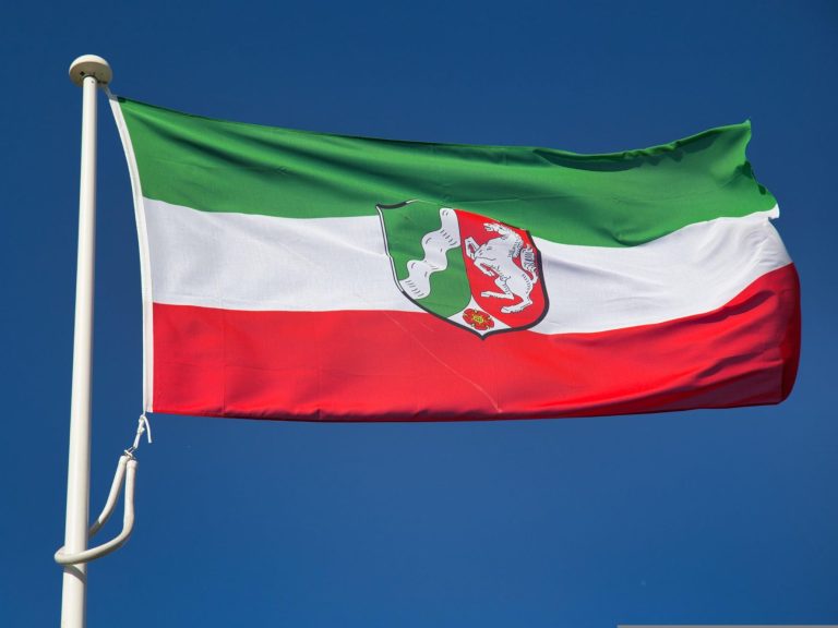Flagge von Nordrhein-Westfalen mit grünem, weißem und rotem Streifen und Wappen.