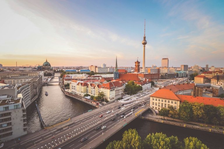 Skyline von Berlin mit Fernsehturm, Spree und historischem Stadtbild bei Sonnenuntergang.