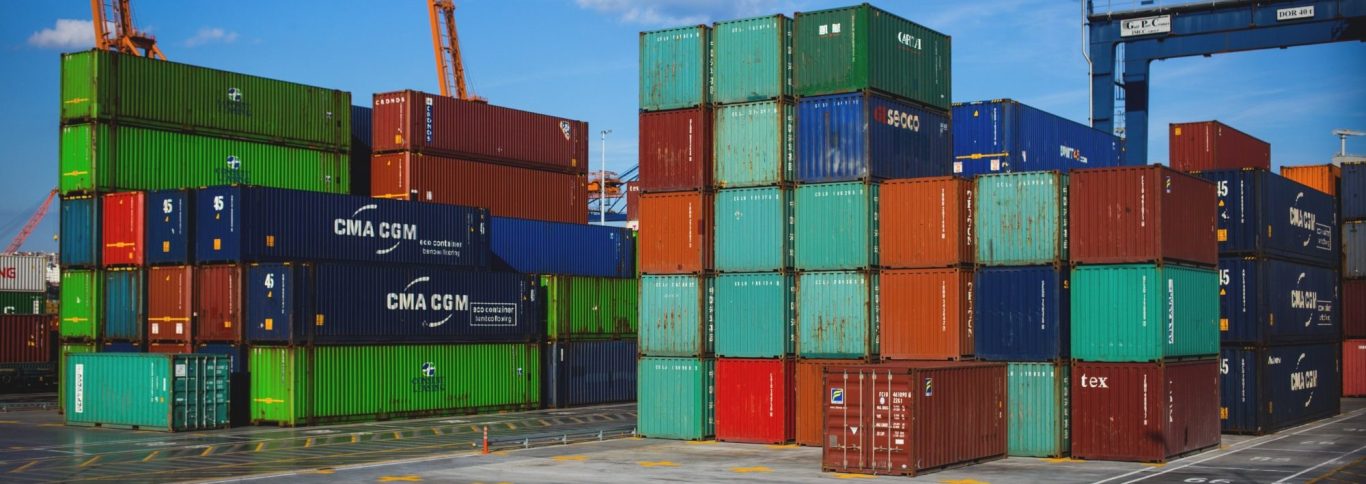 Bunte Frachtschiffscontainer gestapelt in einem Hafenbereich.