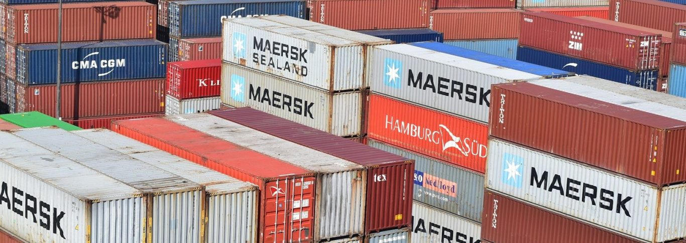 Verschiedene farbige Containerschiffscontainer auf einem Hafenplatz.