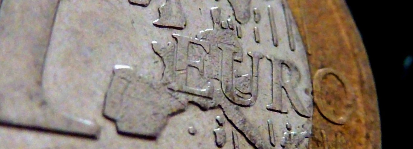 Nahaufnahme einer Münze mit der Aufschrift "Euro" und aufgerauter Oberfläche.