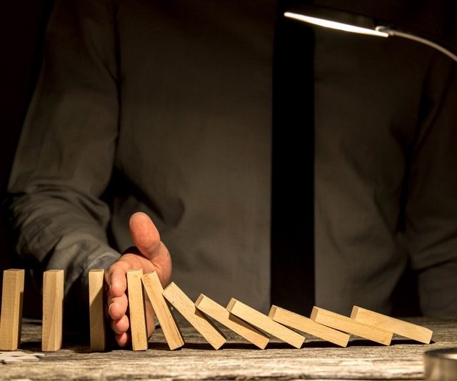 Dominosteine als Symbol dafür, wie ein einzelnes Ereignis eine Kette von Folgen auslösen kann – Wirtschaftsdetektei Schipp in Leipzig. 