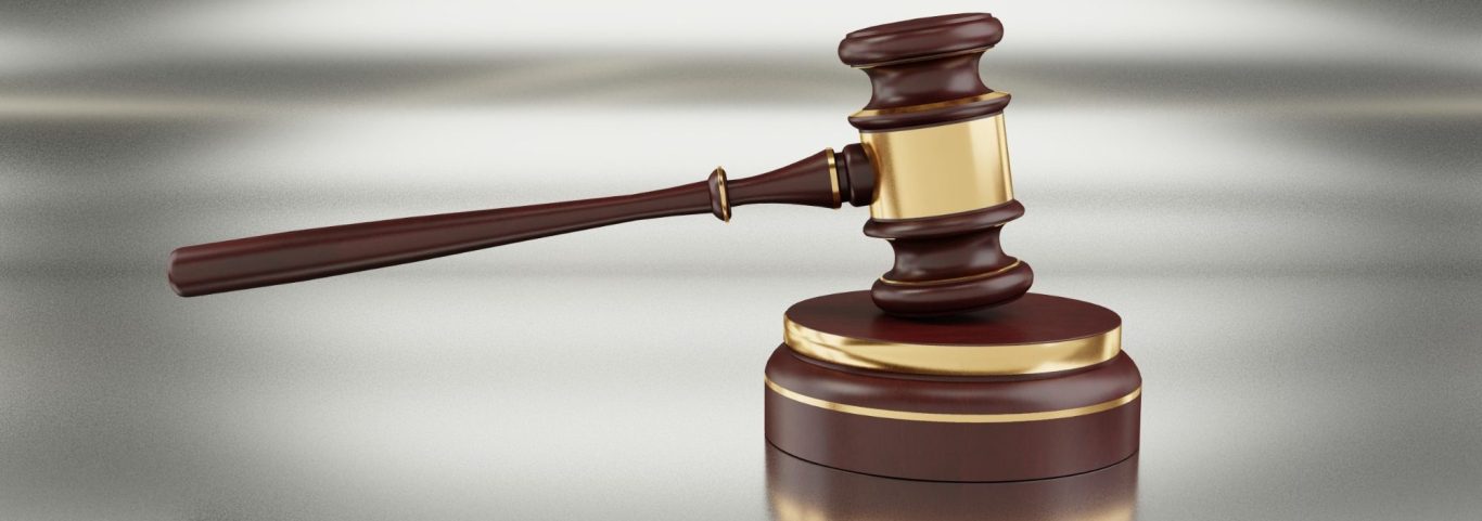 Holzhammer auf einem Richtertisch, Symbol für das Gericht und rechtliche Entscheidungen.