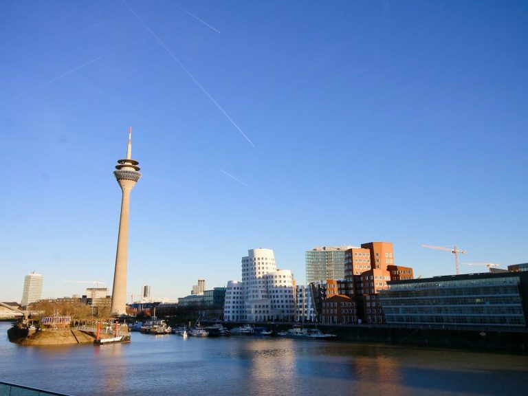 Düsseldorfer Skyline mit Fernsehturm und moderner Architektur am Wasser.